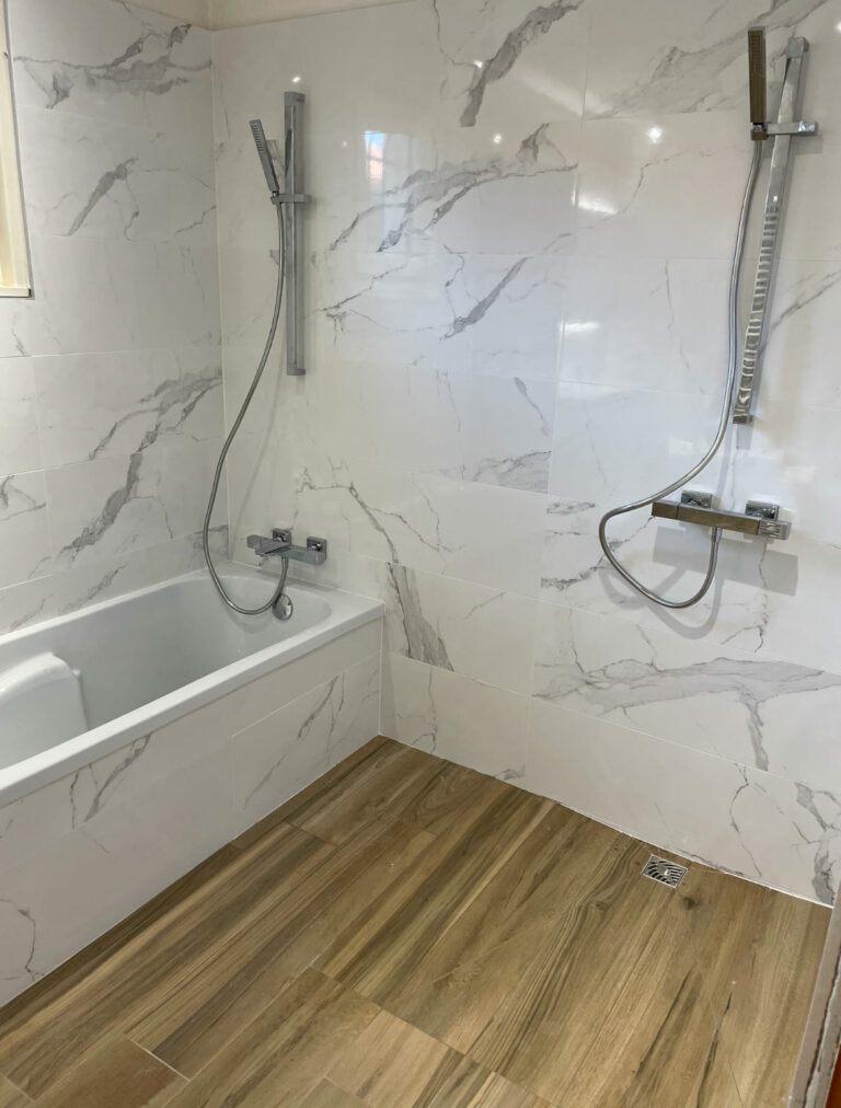Douche à l’italienne avec carrelage clair et paroi vitrée