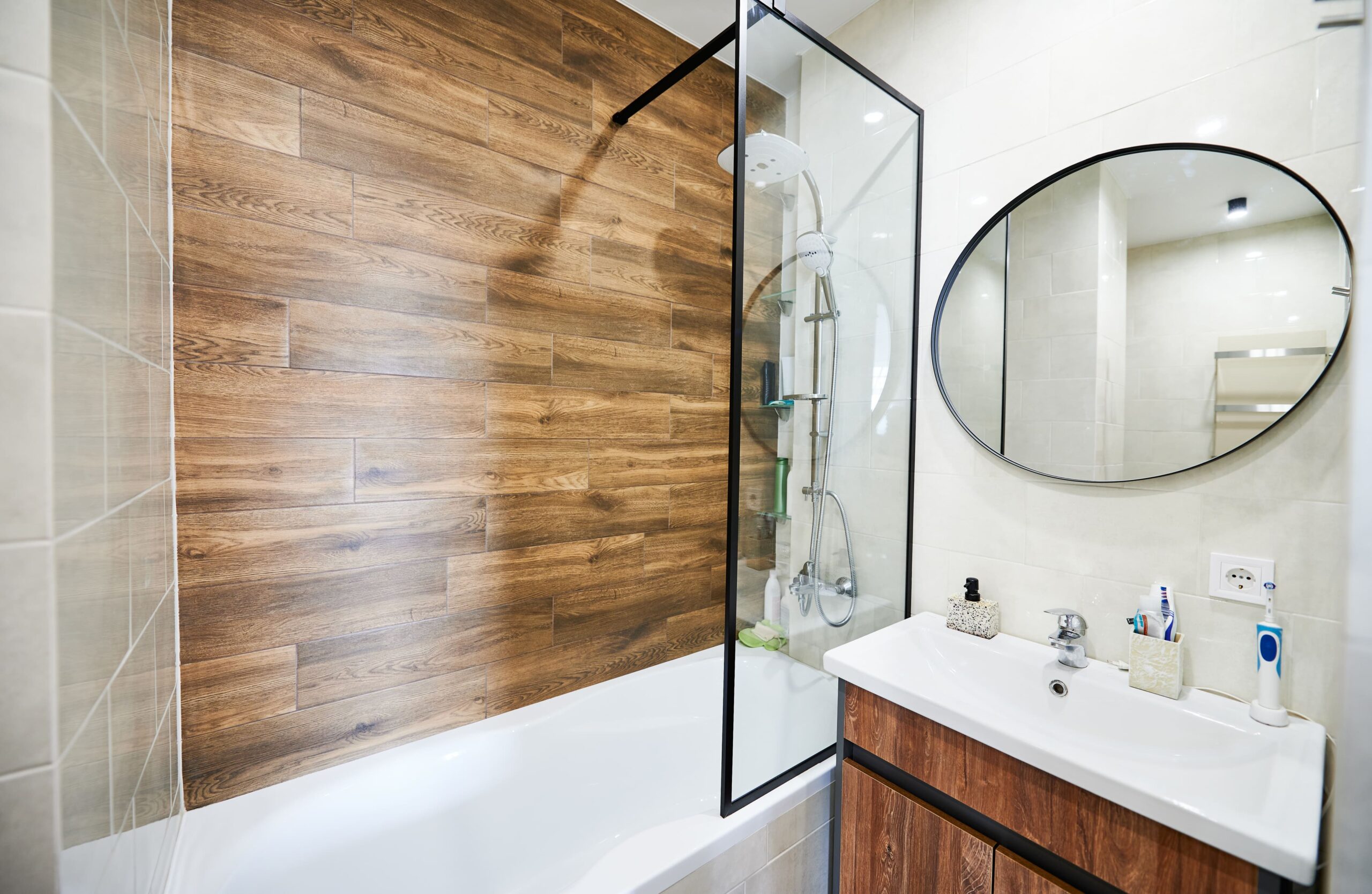 Salle de bain aménagée à La Talaudière : paroi vitrée, carrelage effet bois et meuble suspendu