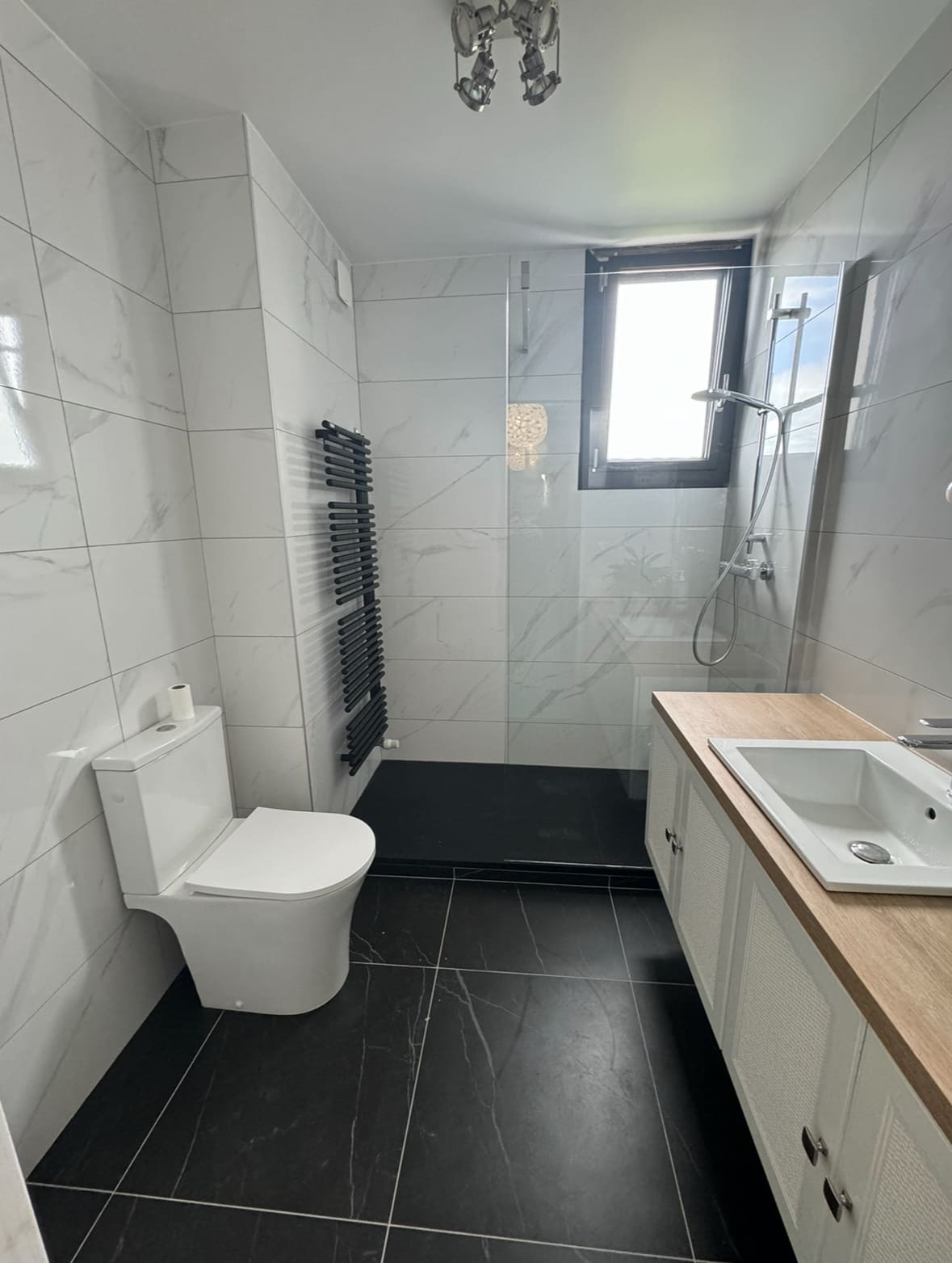 Salle de bain rénovée avec douche à l'italienne et paroi vitrée dans la Loire