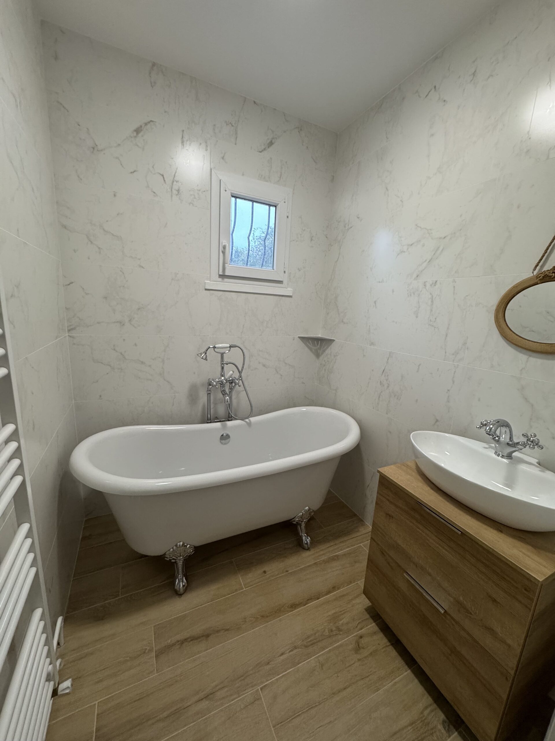 Salle de bain transformée à Saint-Genest-Lerpt : baignoire îlot et meuble vasque sur mesure